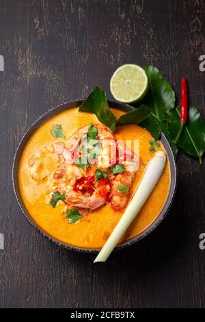 Garnelen Tom Yam Kung in grauen Schale mit thailändischen Gewürzen auf authentisch Fach oben, Holz- Hintergrund. Stockfoto