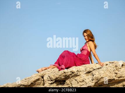 Frau in Kleid steht in der Nähe von Stein Denkmal Stockfoto