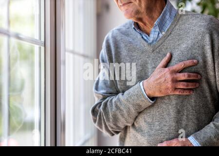 Älterer Mann, der an Brustschmerzen leidet Stockfoto