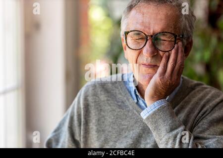 Älterer Mann, der Zahnschmerzen hat Stockfoto