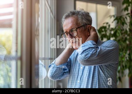 Ältere Mann leidet unter Nackenschmerzen Stockfoto