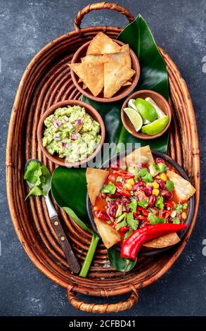 Mexikanische schwarze Bohnensuppe mit hausgemachten frittierten Tortillas totopos nachos Serviert mit Guacamole Stockfoto