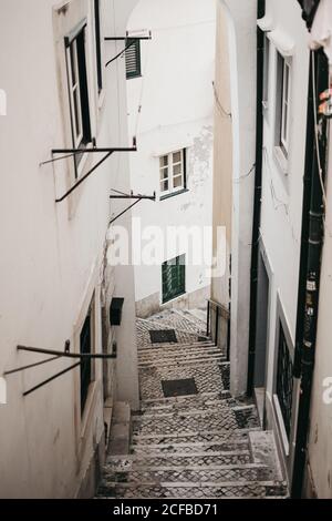 Von oben schäbige Treppe zwischen zwei alten Häusern in der engen Straße von Lissabon, Portugal Stockfoto