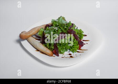 Frischer Salat mit Salat, parmaschinken und Parmesan auf weißem Hintergrund Stockfoto