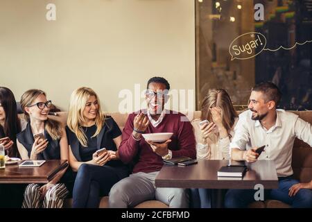 Geschäftsleute essen, reden und lächeln beim Mittagessen im Café Stockfoto