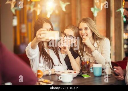 Geschäftsleute, die im Café Selfie von sich selbst machen Stockfoto