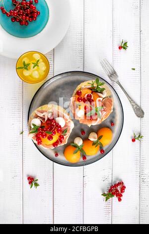 Teller mit Melone italienischen Prosciutto und Mozzarella mit roten verziert Johannisbeere und Minzblätter Stockfoto