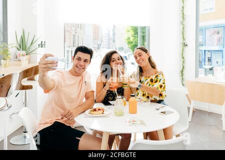 Mann nimmt Selfie von Freunden im Café Stockfoto