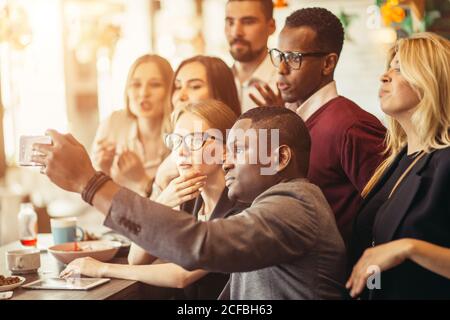 Geschäftsleute, die im Café Selfie von sich selbst machen Stockfoto