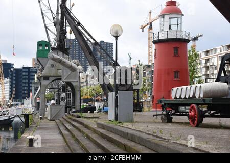 Einige der Ausstellungsstücke des nationalen Schifffahrtsmuseums in Rotterdam wurden im Freien ausgestellt. Auf dem Bild sind roter Leuchtturm, Hafenkran und Radauto. Stockfoto