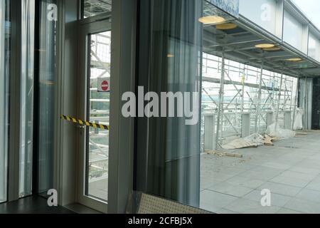 Geschlossene Tür und blockiert mit Sperrband und kein Eingangsschild zur Terrasse, die rekonstruiert und mit Gerüsten bedeckt wird. Stockfoto