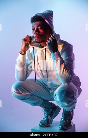 Stilvoller schwarzer Mann auf Würfel Stockfoto