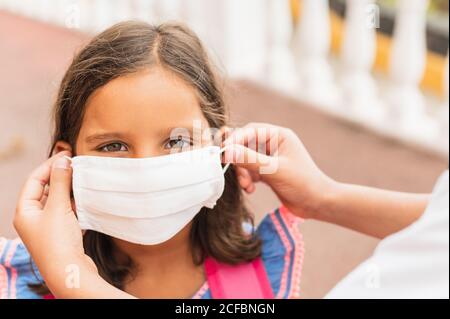 Mutter zieht ihr Kind sterile medizinische Maske an. Kind, tragen Gesichtsmaske, vor Infektionen von Viren, Pandemie, Ausbruch und Epidemie der Krankheit zu schützen Stockfoto