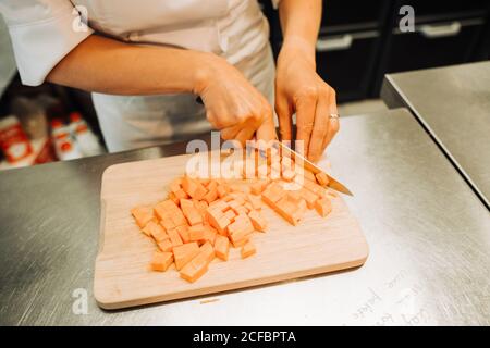 Küchenchef schneidet Kürbis in einem Restaurant, Nahaufnahme Stockfoto