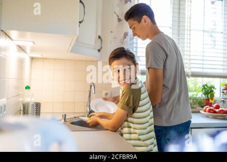 Zwei Jungen waschen das Geschirr im Spülbecken Stockfoto