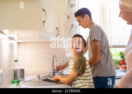 Zwei Jungen waschen das Geschirr im Spülbecken Stockfoto