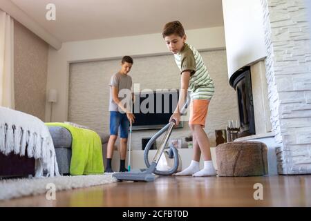 Junge Staubsaugen Boden zu Hause Stockfoto