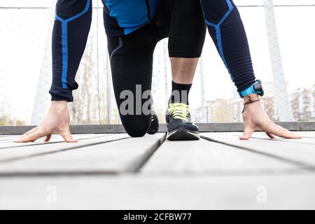 Reife männliche Jogger in Trainingsbekleidung Vorbereitung auf laufen Holzsteg am Flussufer Stockfoto