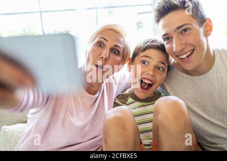 Mutter mit ihren beiden Söhnen, die zu Hause Selfie machen Stockfoto