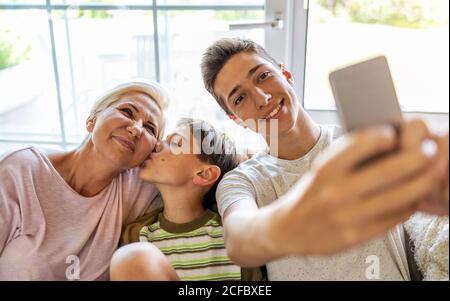Mutter mit ihren beiden Söhnen, die zu Hause Selfie machen Stockfoto