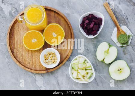 Von oben serviert Orangen Erdnüsse und Orangensaft auf dem Tisch Mit Apfelwürz und Schüssel mit Rüben und Äpfeln Stockfoto