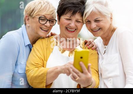 Gruppe von älteren Frauen, die Smartphones zusammen verwenden Stockfoto