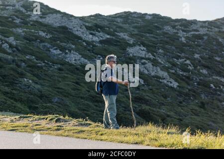 Seitenansicht eines älteren Mannes, der durch den Berg wandert Stockfoto