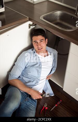 Portrait von männlichen Klempner Befestigung einer Spüle in der Küche Stockfoto