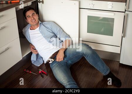 Portrait von männlichen Klempner Befestigung einer Spüle in der Küche Stockfoto