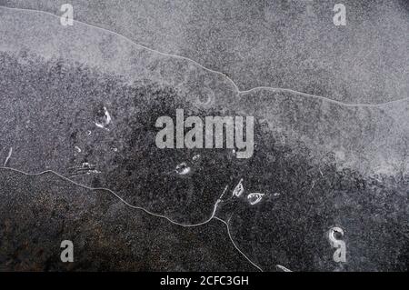 Fragment von dünnem Eis auf dunklem gefrorenem Fluss Stockfoto