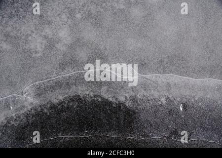 Fragment von dünnem Eis auf dunklem gefrorenem Fluss Stockfoto