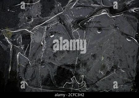 Fragment von dünnem Eis auf dunklem gefrorenem Fluss Stockfoto