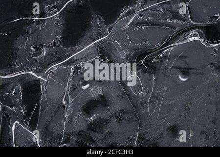 Fragment von dünnem Eis auf dunklem gefrorenem Fluss Stockfoto