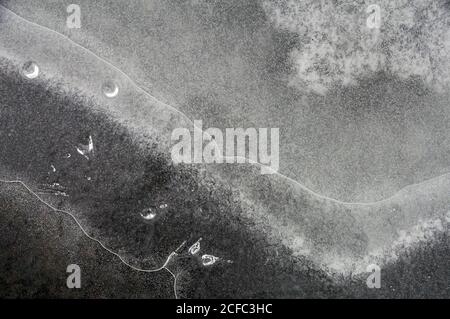 Fragment von dünnem Eis auf dunklem gefrorenem Fluss Stockfoto