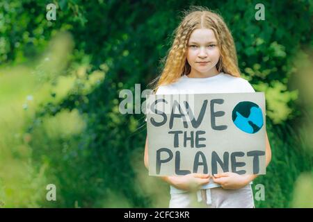 kaukasische blonde Mädchen Aktivist mit retten den Planeten Poster im Park. Preteen Kind Freiwilligen gegen Verschmutzung, globale Erwärmung, Müll zu recyceln. Ökologie Stockfoto