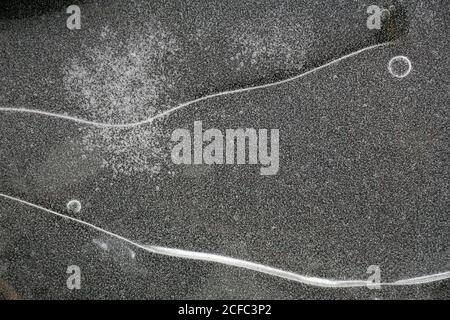 Fragment von dünnem Eis auf dunklem gefrorenem Fluss Stockfoto