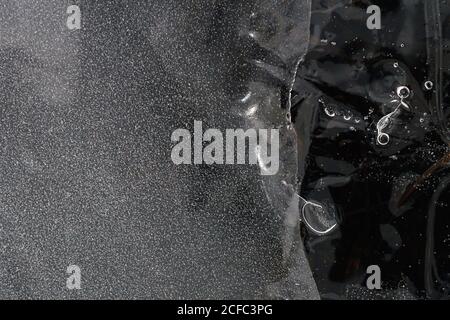 Fragment von dünnem Eis auf dunklem gefrorenem Fluss Stockfoto