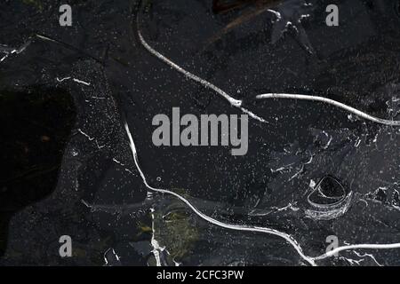 Fragment von dünnem Eis auf dunklem gefrorenem Fluss Stockfoto