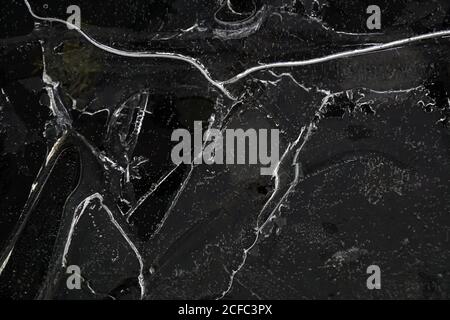 Fragment von dünnem Eis auf dunklem gefrorenem Fluss Stockfoto