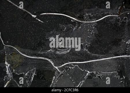 Fragment von dünnem Eis auf dunklem gefrorenem Fluss Stockfoto