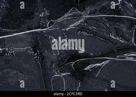 Fragment von dünnem Eis auf dunklem gefrorenem Fluss Stockfoto
