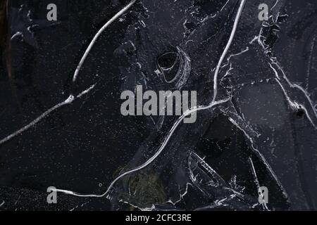 Fragment von dünnem Eis auf dunklem gefrorenem Fluss Stockfoto