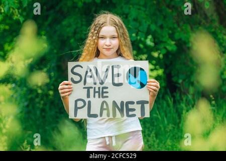 Kind Mädchen Aktivist mit retten den Planeten Poster im Waldpark. Preteen Kind Freiwilligen Kampf gegen Verschmutzung, Globale Erwärmung, Müll zu recyceln. Ecolog Stockfoto