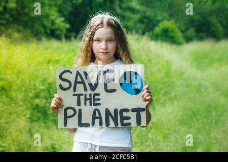 Kind Mädchen Aktivist mit retten den Planeten Poster im Waldpark. Preteen Kind Freiwilligen Kampf gegen Verschmutzung, Globale Erwärmung, Müll zu recyceln. Ecolog Stockfoto