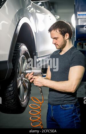 Automechaniker ändern Auto Rad im Auto Reparatur garage Stockfoto