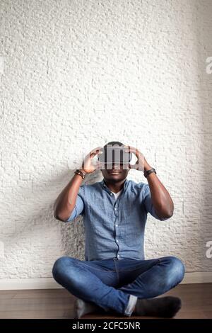 Junger bärtiger Mann mit Virtual Reality Brille im modernen Interior Design Coworking Studio. Smartphone mit VR Brille Headset. Stockfoto