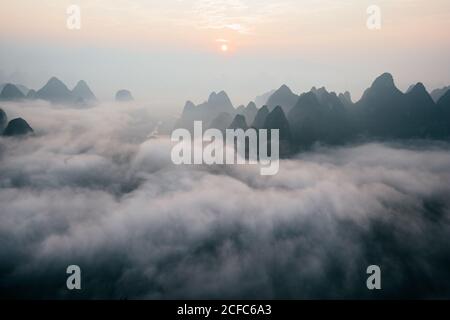 Geheimnisvolle Flusslandschaft zwischen hohen Bergen im Dunst Stockfoto