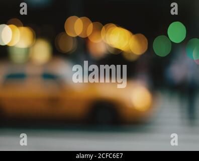 Verschwommenes Stadtbild mit gelben Taxis, die an der New York Street vorbeifahren Voller heller Bokeh Lichter der Stadt Stockfoto