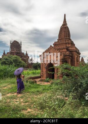 Frau mit Regenschirm vor dem alten Tempel Stockfoto