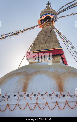 Niedriger Winkel der alten buddhistischen hemisphärischen Denkmal mit Ornament und Dekorative Augen auf Turm mit kleiner Kuppel und Girlanden auf Am Nachmittag oben unter dem Himmel Stockfoto